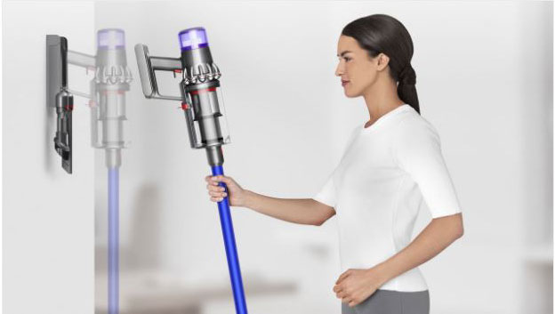 A vaccum clean is being docked back to a docking station on the wall